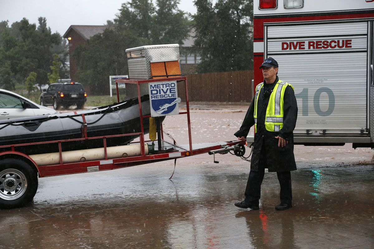 A police officer allows a special dive rescue team to pass on a closed road following overnight flash flooding in downtown Boulder, Colo., on Thursday.