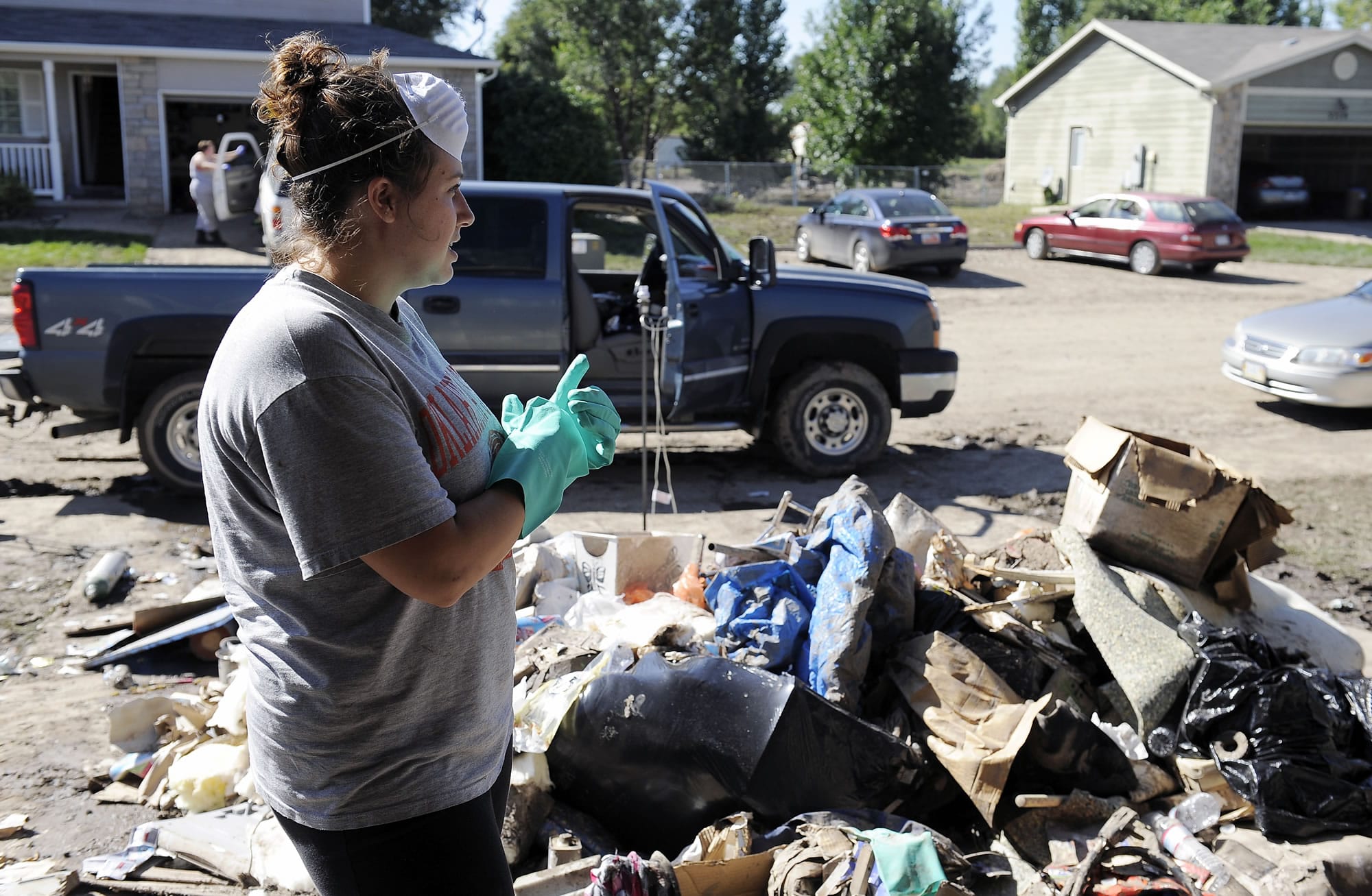 Tara Anderson, 25, takes a break from cleaning out her flood-damaged home in Evans, Colo., on Friday.