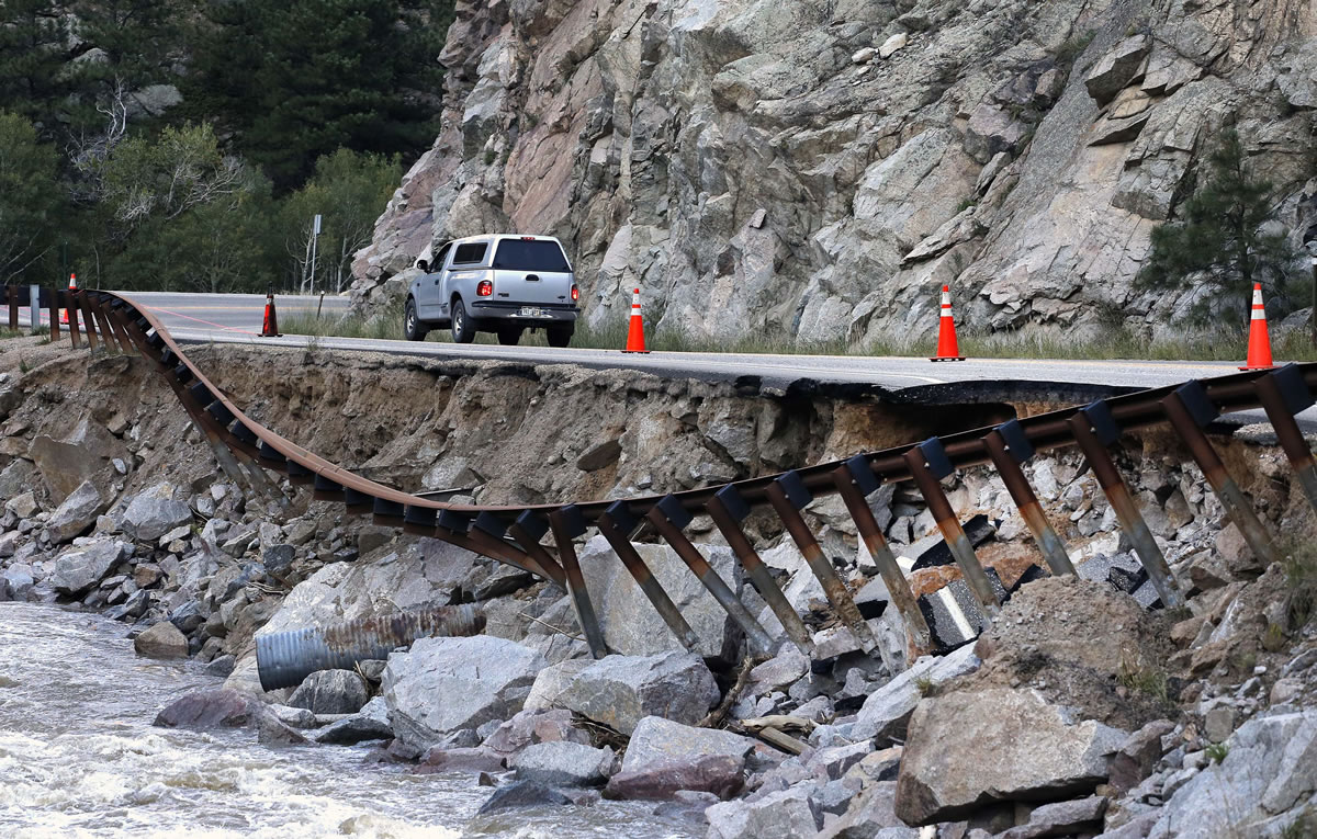 A guardrail hangs away from a closed canyon road, where some local residents are allowed to drive with caution, and which is washed out in places by recent flooding, up Boulder Canyon, west of Boulder, Colo., on Friday.