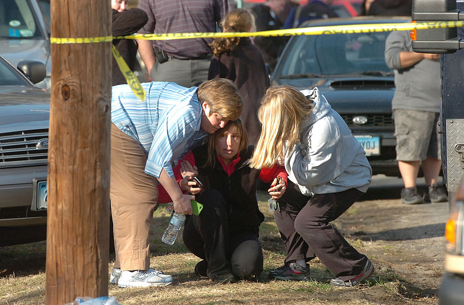 A woman is comforted near the school.