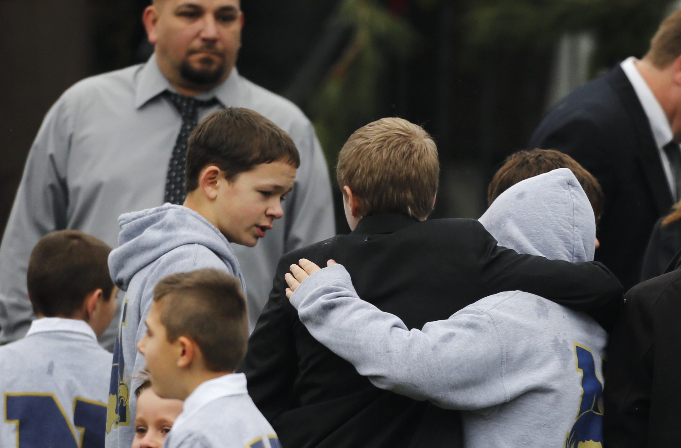 Students embrace while wearing Newtown school shirts outside the funeral for 6-year-old shooting victim Jack Pinto in Newtown, Conn., on Monday.