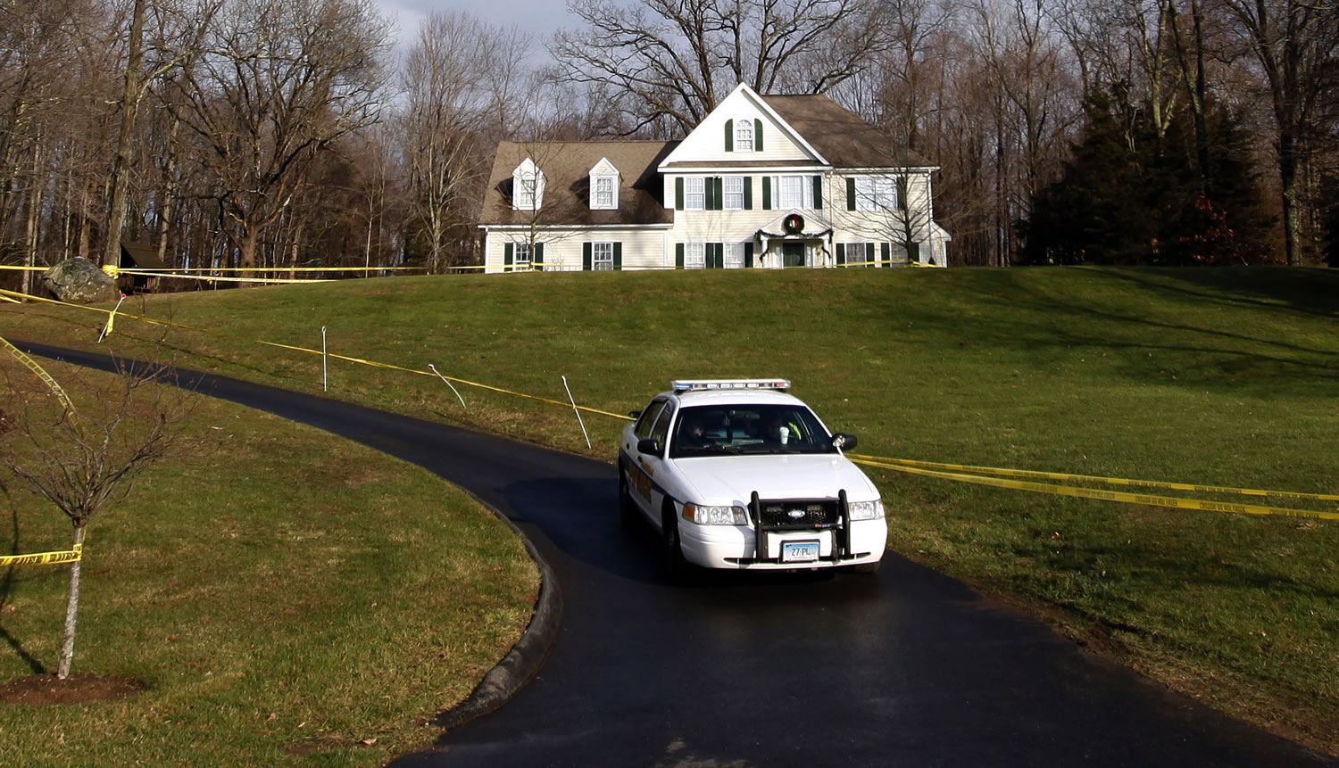 A police cruiser sits in the driveway and crime scene tape surrounds the home of Nancy Lanza in Newtown, Conn., in December.