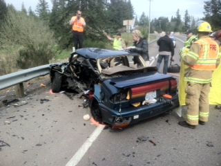 Emergency responders examine the remains of a car driven by Marcos Castillo of Vancouver.