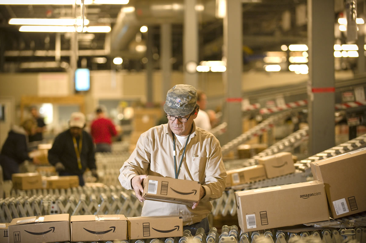 An Amazon.com employee grabs a box off a conveyor belt in 2008 at the retailer's Fernley, Nev., warehouse.
