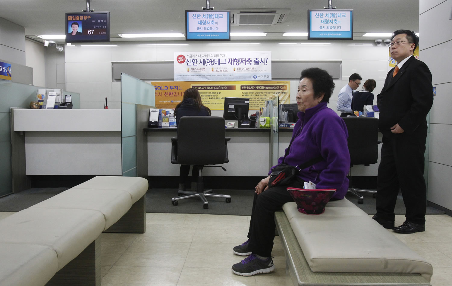 In this March 20, 2013 photo, a customer sits in a branch of Shinhan Bank in Seoul, South Korea, after the bank's computer networks was paralyzed. The hackers who knocked out tens of thousands of South Korean computers simultaneously this year are out to do far more than erase hard drives, cybersecurity firms say: They also are trying to steal South Korean and U.S. military secrets with a malicious set of codes theyive been sending through the Internet for years.