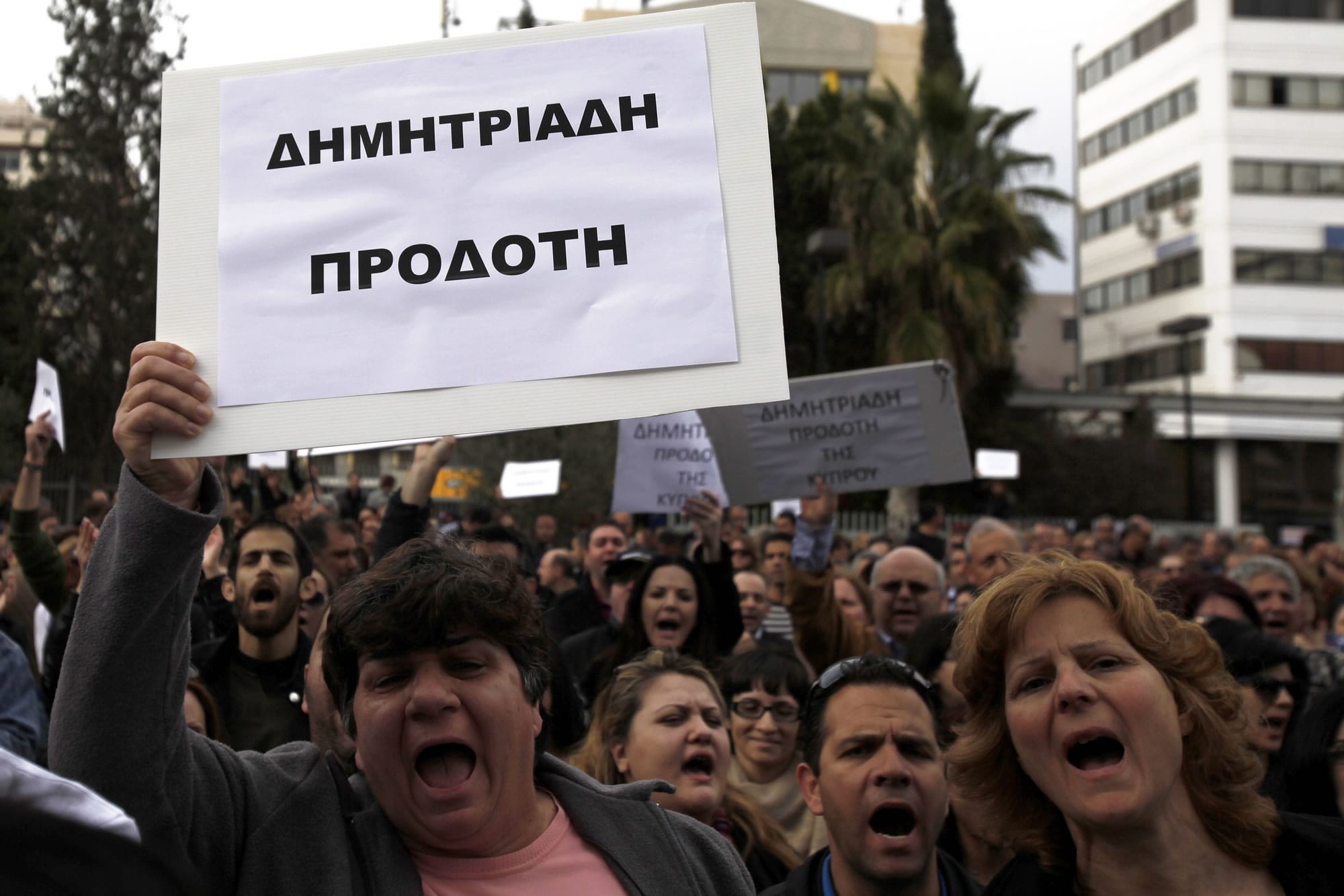 Employees of Bank of Cyprus shout slogans and wave a banner reading in Greek &quot;Demitriades Traitor&quot; referring to Cyprus Central Bank Governor Panicos Demetriades, during a protest at Cyprus central bank in capital Nicosia, Cyprus, on Tuesday.