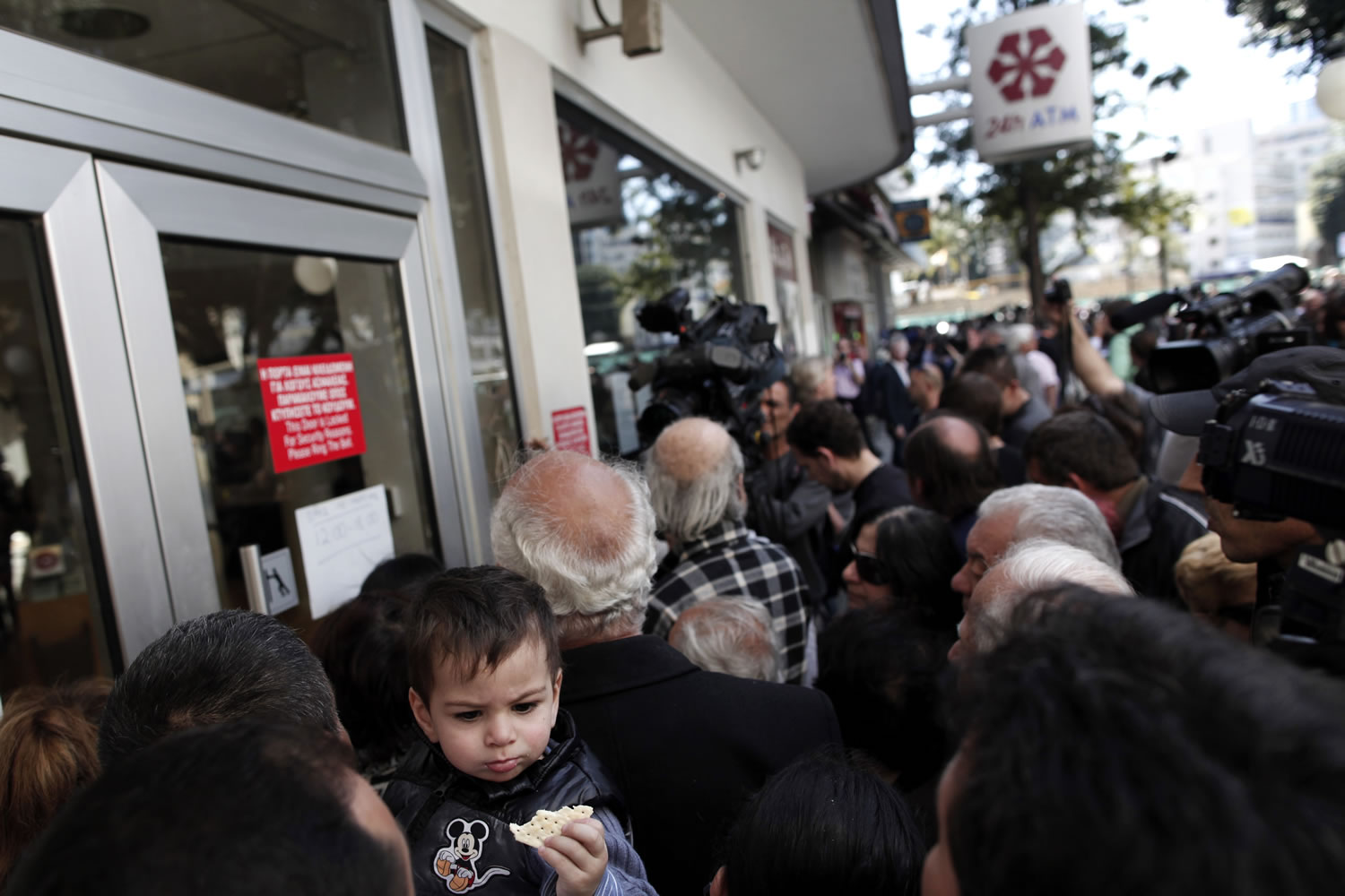 People wait outside a branch of Laiki Bank in Nicosia on Thursday.