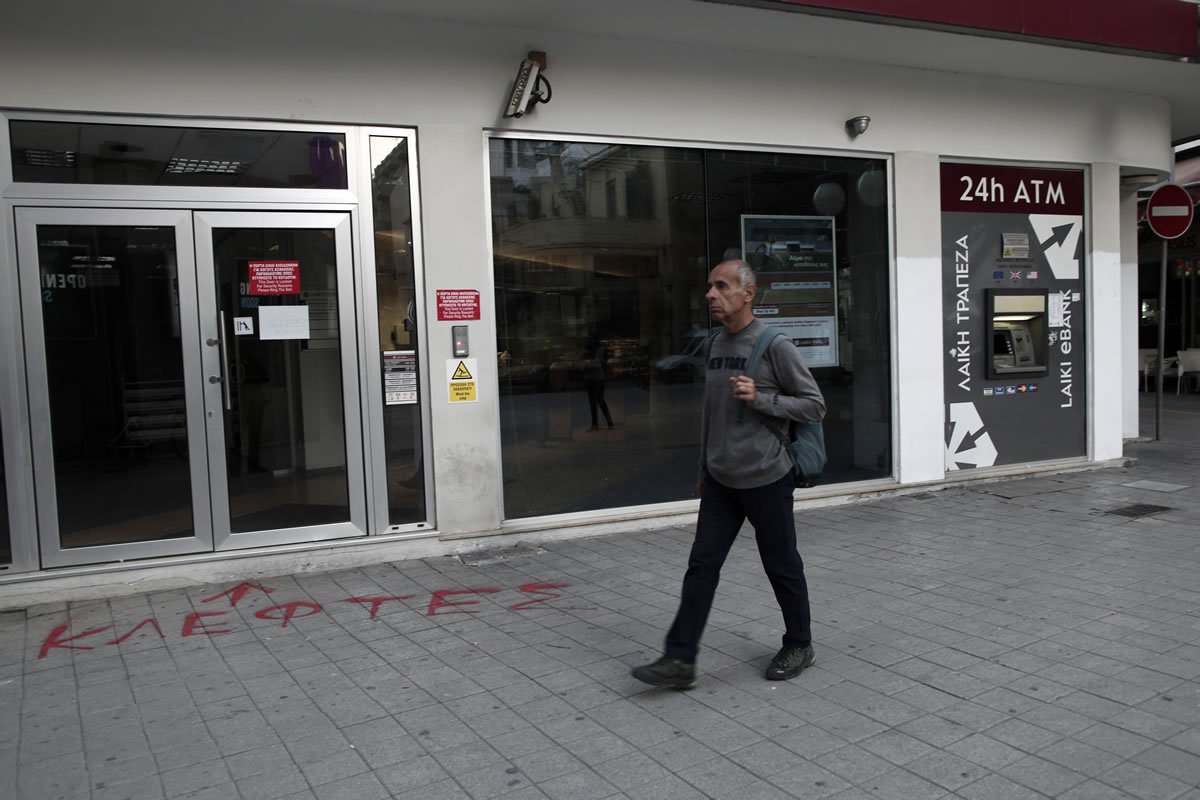 At the entrance of a closed Laiki Bank, graffiti sprayed on the pavement in Greek reads &quot;thieves&quot; capital Nicosia, Cyprus, on Wednesday.
