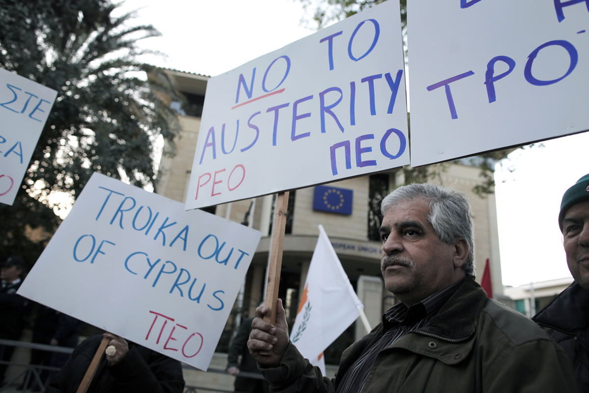 Protesters hold placards outside the European Union house during an anti-bailout demonstration in the capital Nicosia, Cyprus, on Wednesday.