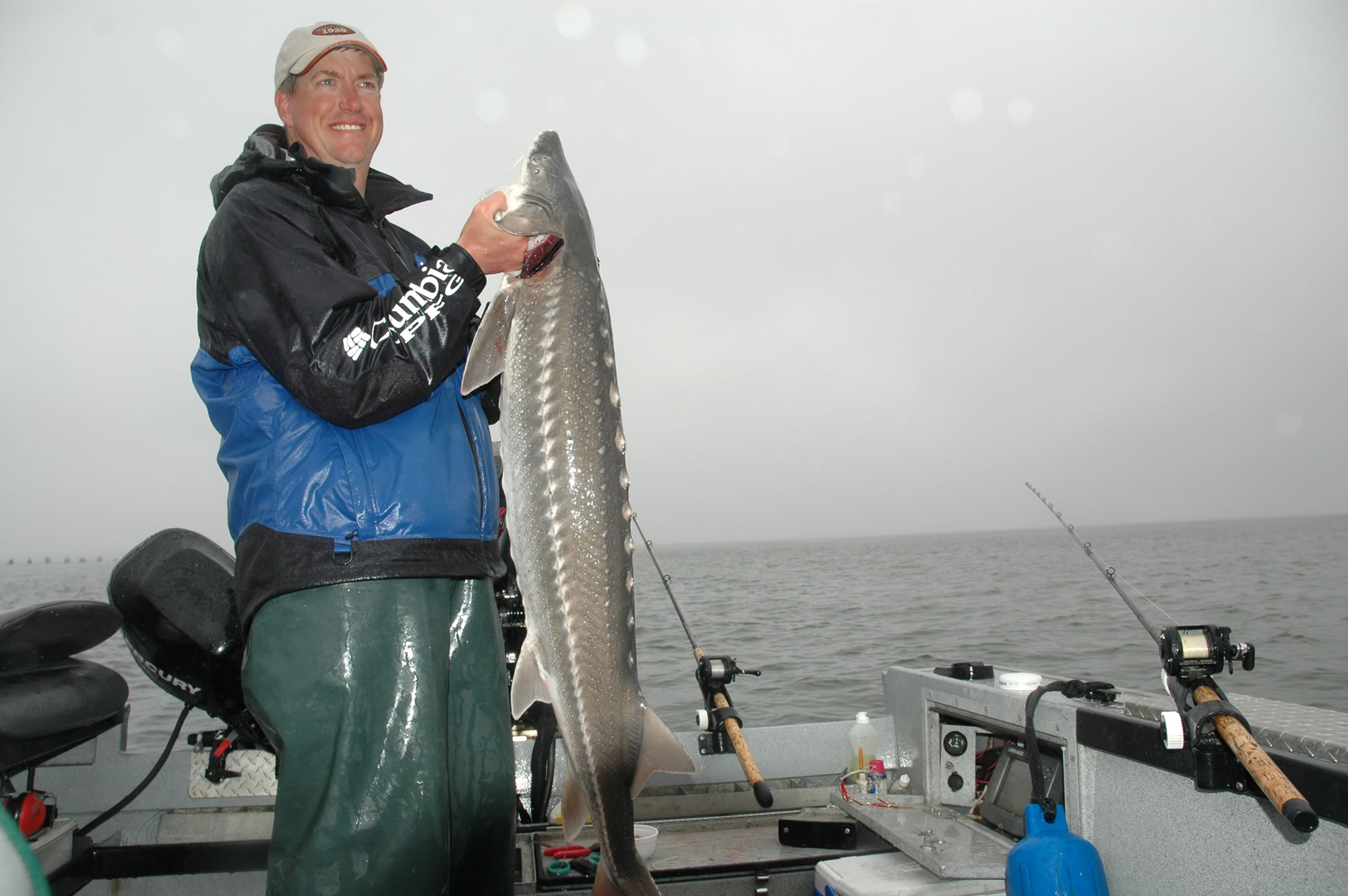 Guide Bob Rees holds a sturgeon caught in early June near the Port of Hammond at the mouth of the Columbia River.