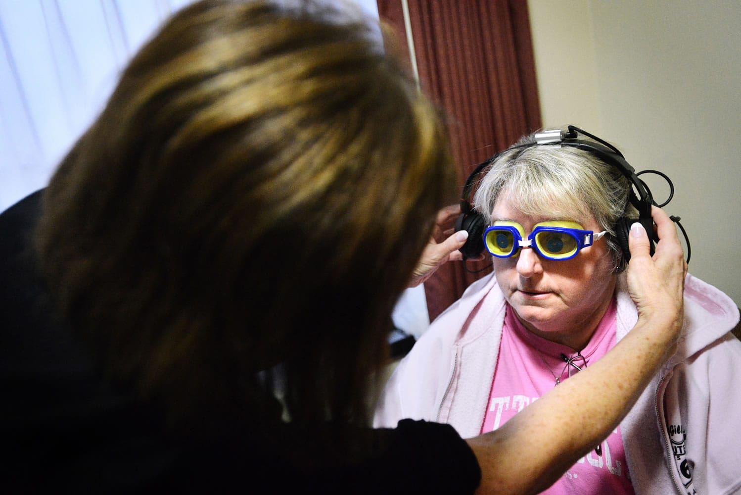 Gayle Yoder of Echo, Ore., has headphones placed on her ears by Kathy Thomas, a Good Shepherd health educator, before taking a virtual dementia tour in Hermiston, Ore.