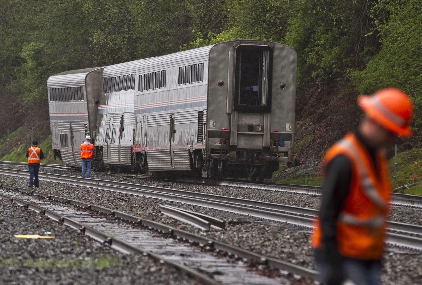 Three cars from an Amtrak train that was carrying passengers sit derailed on a track in Everett after the locomotive portion of the train continued on towards Seattle on Sunday.
