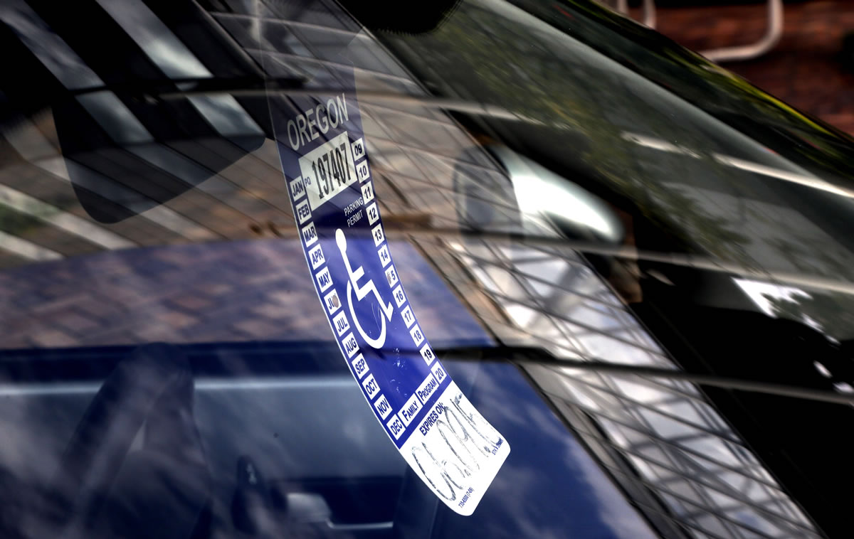 A handicapped parking tag hangs from the rearview mirror of a car parked at a metered parking spot in Portland on Tuesday.