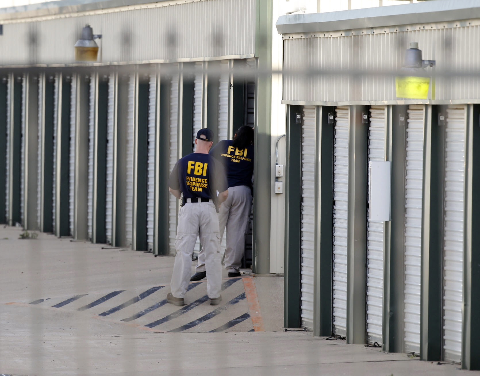 Authorities search a storage unit at Gibson Self Storage as they continue to investigate the slayings of Kaufman County District Attorney Mike McLelland, his wife and a top prosecutor on Saturday in Seagoville, Texas.