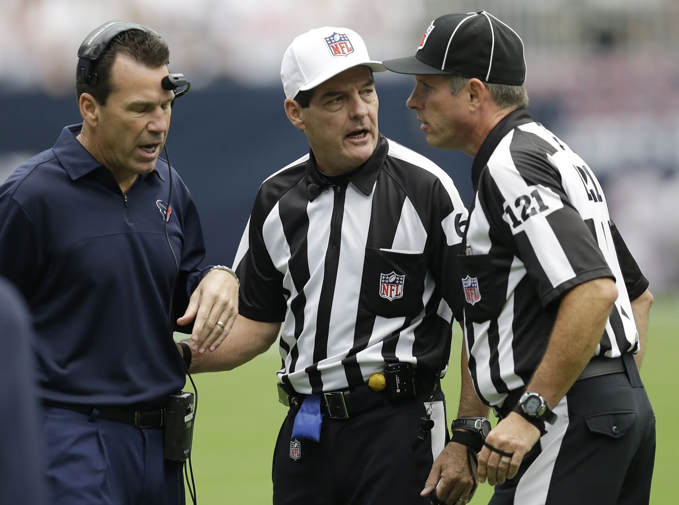 Houston Texans coach Gary Kubiak, left, discusses a play with referees Don King (60) and Curtis Townsend (121) in the first quarter of an NFL football game against the Miami Dolphins, Sunday, Sept. 9, 2012, in Houston. (AP Photo/David J.