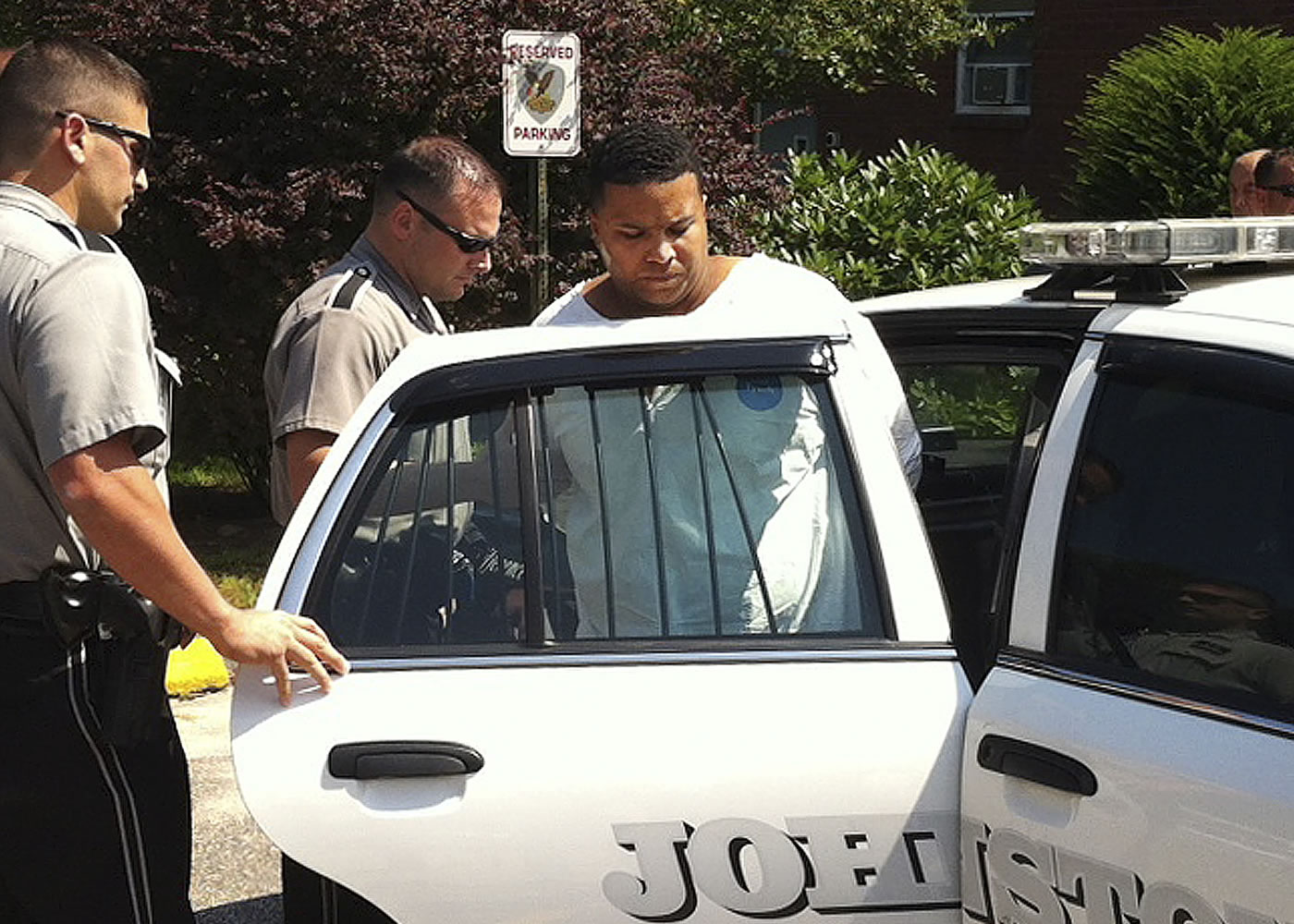 Daniel Rodriguez is put into a squad car outside police headquarters Monday in Johnston, R.I.