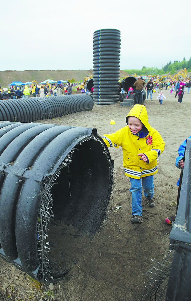 Jaden Zollbrecht, 5, of Damascus, Ore., runs toward a pipe maze set up for children during last year's Dozer Day fundraiser at the Cemex/Fisher Quarry.