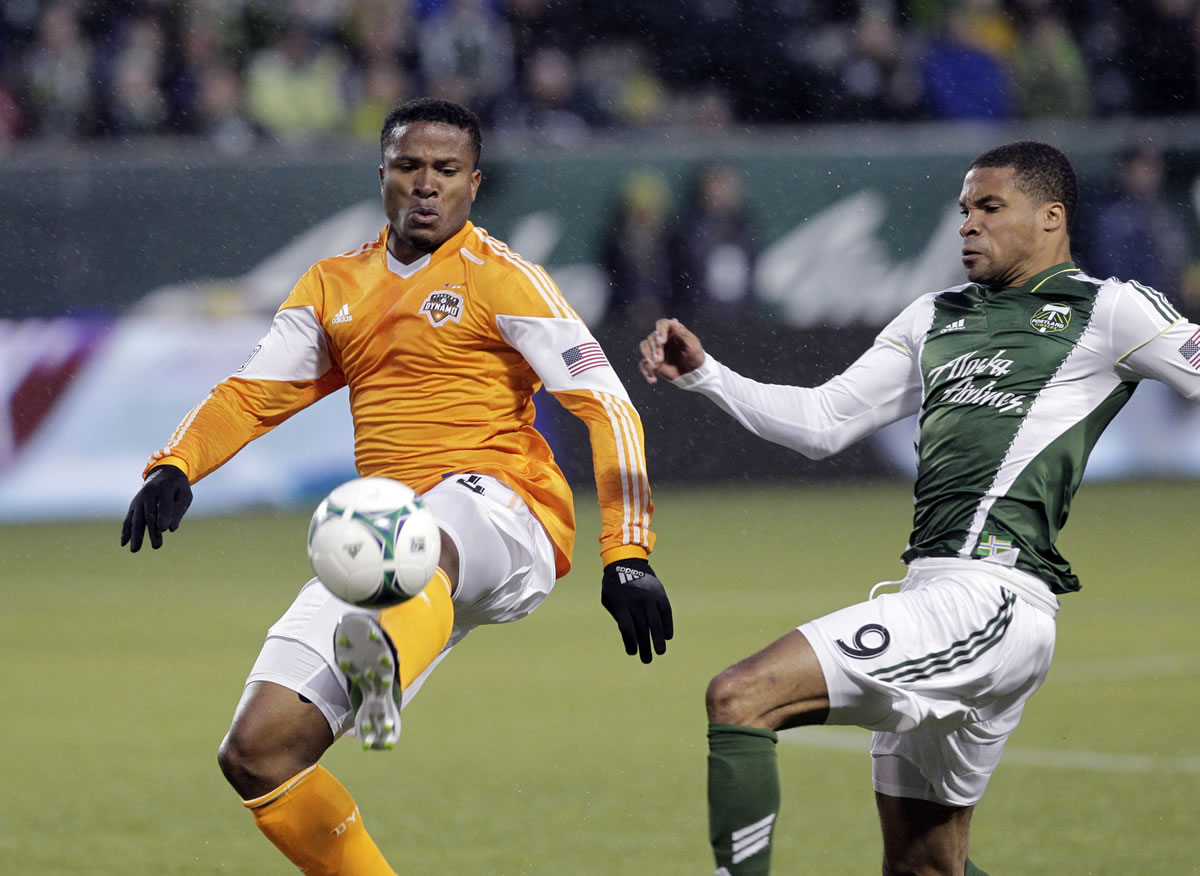 Houston Dynamo defender Jermaine Taylor, left, pulls in the ball as Portland Timbers forward Ryan Johnson challenges during the first half Saturday.