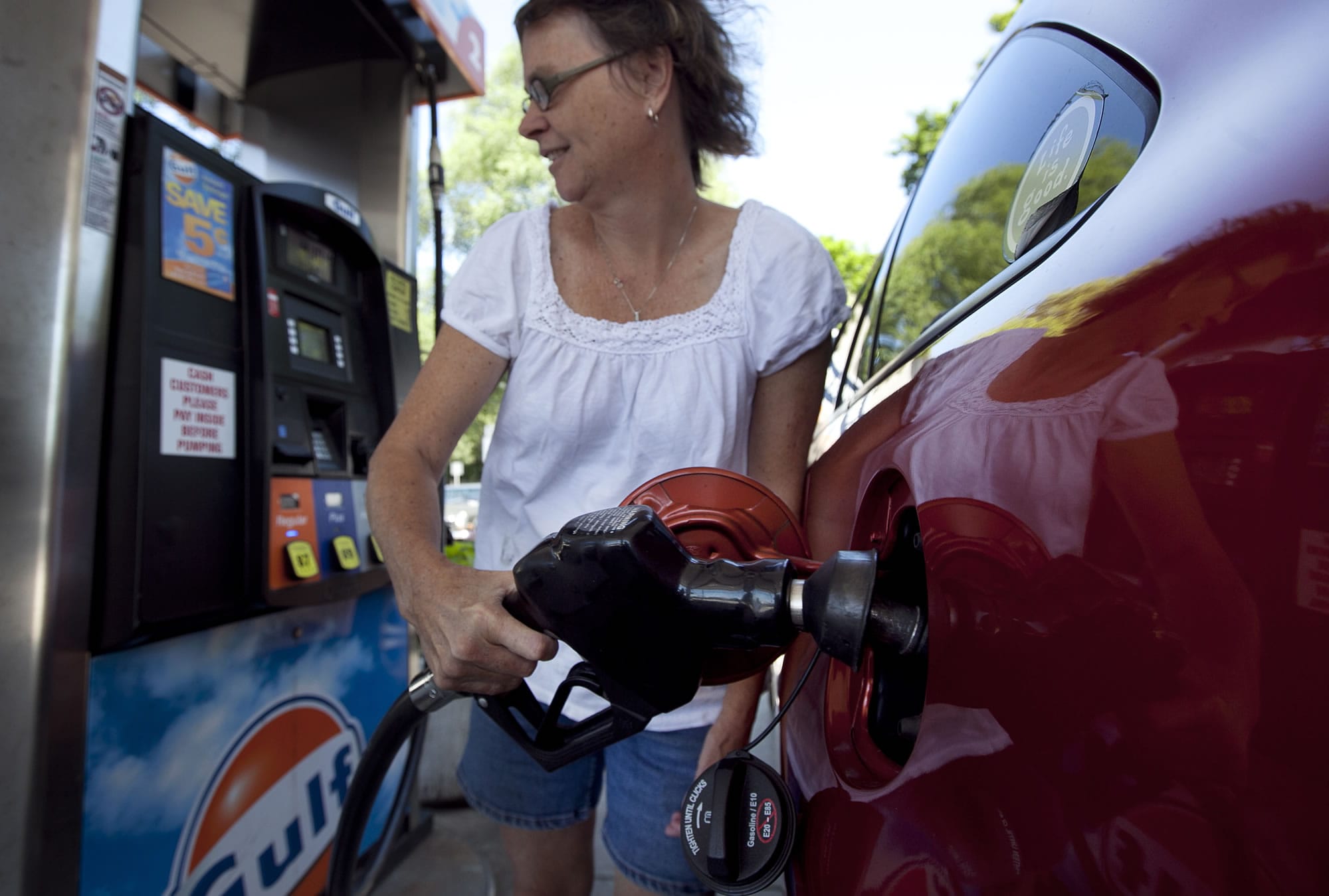 Suzanne Meredith of Walpole, Mass., fuels her car at a Gulf station in Brookline, Mass.
