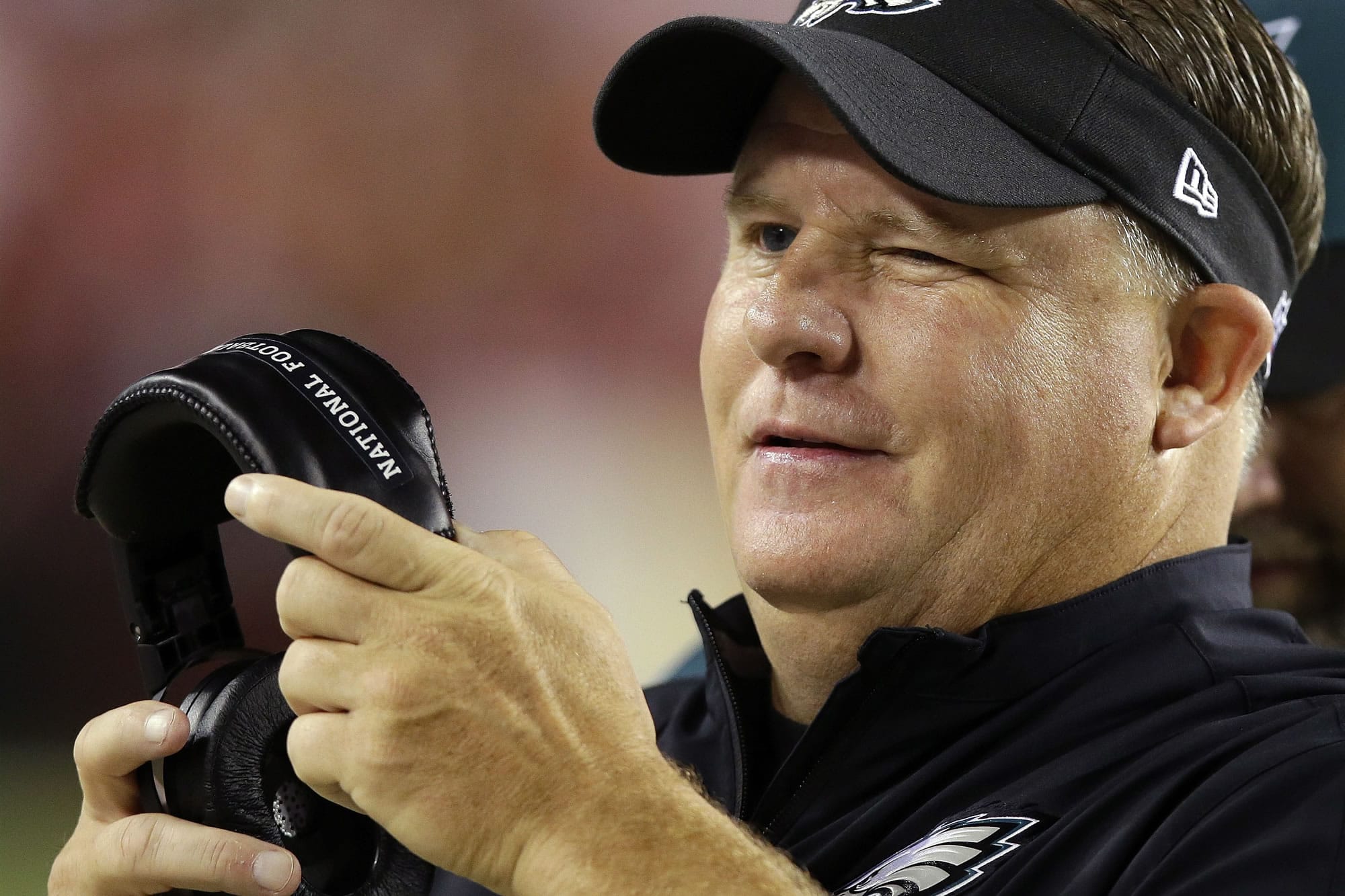 Philadelphia Eagles head coach Chip Kelly winks as he watchers the action on the field during the second half of an NFL football game against the Washington Redskins in Landover, Md., Monday, Sept. 9, 2013.