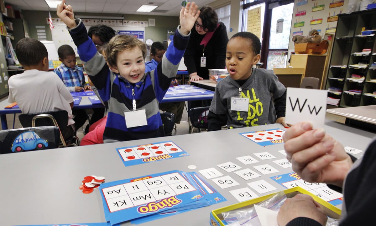 Joel McCain, left, reacts to winning a letter bingo game Wednesday as Christopher Larry Jr., looks on in their kindergarten classroom at Campbell Hill Elementary in Renton.