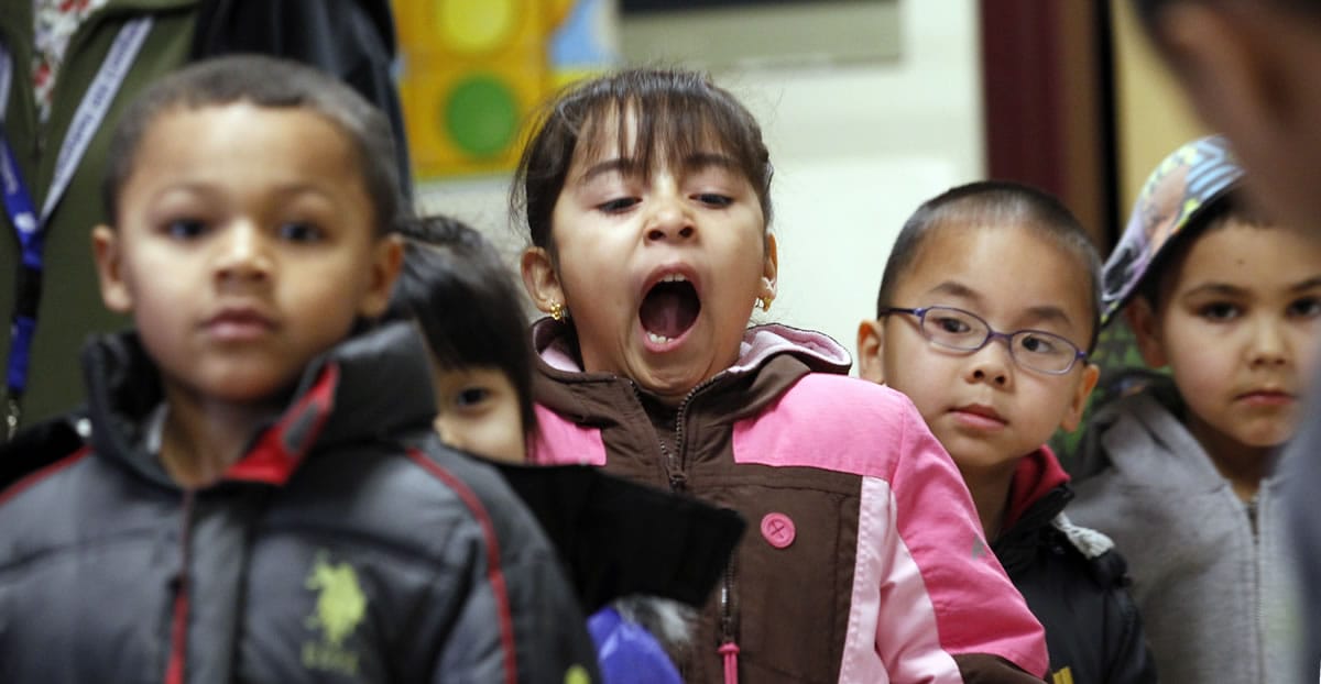 Victoria Espino yawns Wednesday as she stands with her kindergarten classmates as they wait to go outside for recess at Campbell Hill Elementary in Renton.
