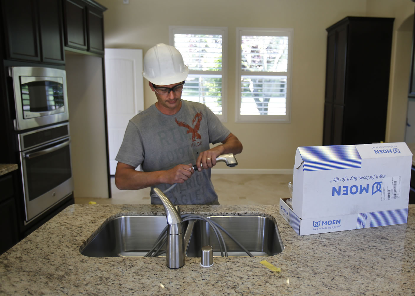 Plumber Daniel Bordwell installs a kitchen faucet on a home under construction in Sacramento, Calif. on June 21. Another solid month of hiring in June could signal the start of a stronger second half of the year for the U.S. economy. The Fed's low interest-rate policies have encouraged more Americans to buy homes and cars.