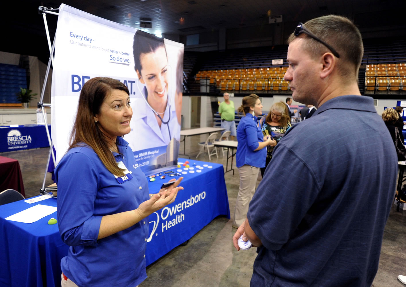 Registered nurse Salanda Bowman, left, talks with part-time Kentucky Wesleyan College student Jason Ward, of Whitesville, about job openings at the Owensboro Health Regional Hospital during a Regional Career and Job Fair in the Owensboro Sports Center in Owensboro, Ky.