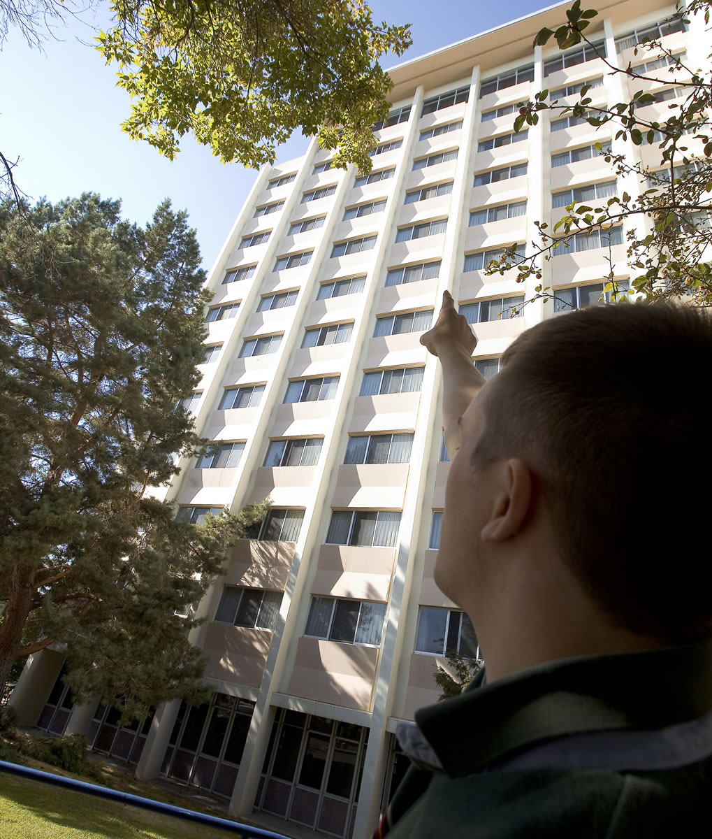 Brady Seroshek, 21, of Longview, points to the window Thursday near the top of Orton Hall in Pullman, where a fellow Washington State University student fell Wednesday from an 11th-floor dormitory room and survived.