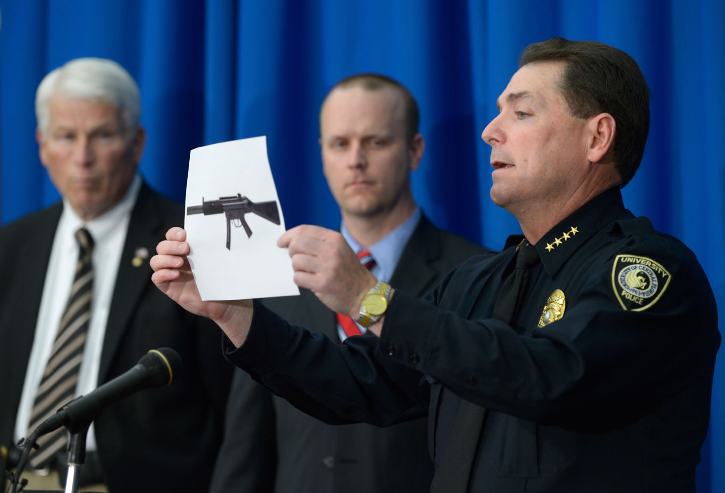 University of Central Florida police Chief Richard Beary, right, shows an example of the assault rifle, along with explosive devices, found in the dorm room of James Oliver Seevakumaran, who died of an apparent suicide in the room Monday in Orlando, Fla.