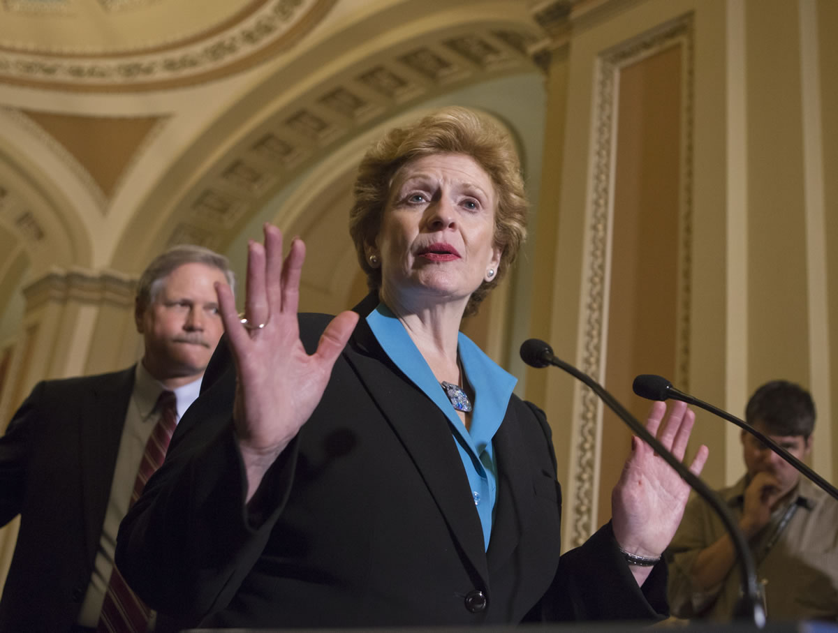 Sen. Debbie Stabenow, D-Mich., chairwoman of the Senate Agriculture Committee, speaks to reporters as the Senate votes on a farm bill that sets policy for farm subsidies, food stamps and other farm and food aid programs for the next five years at the Capitol in Washington on Monday. At rear is Sen.
