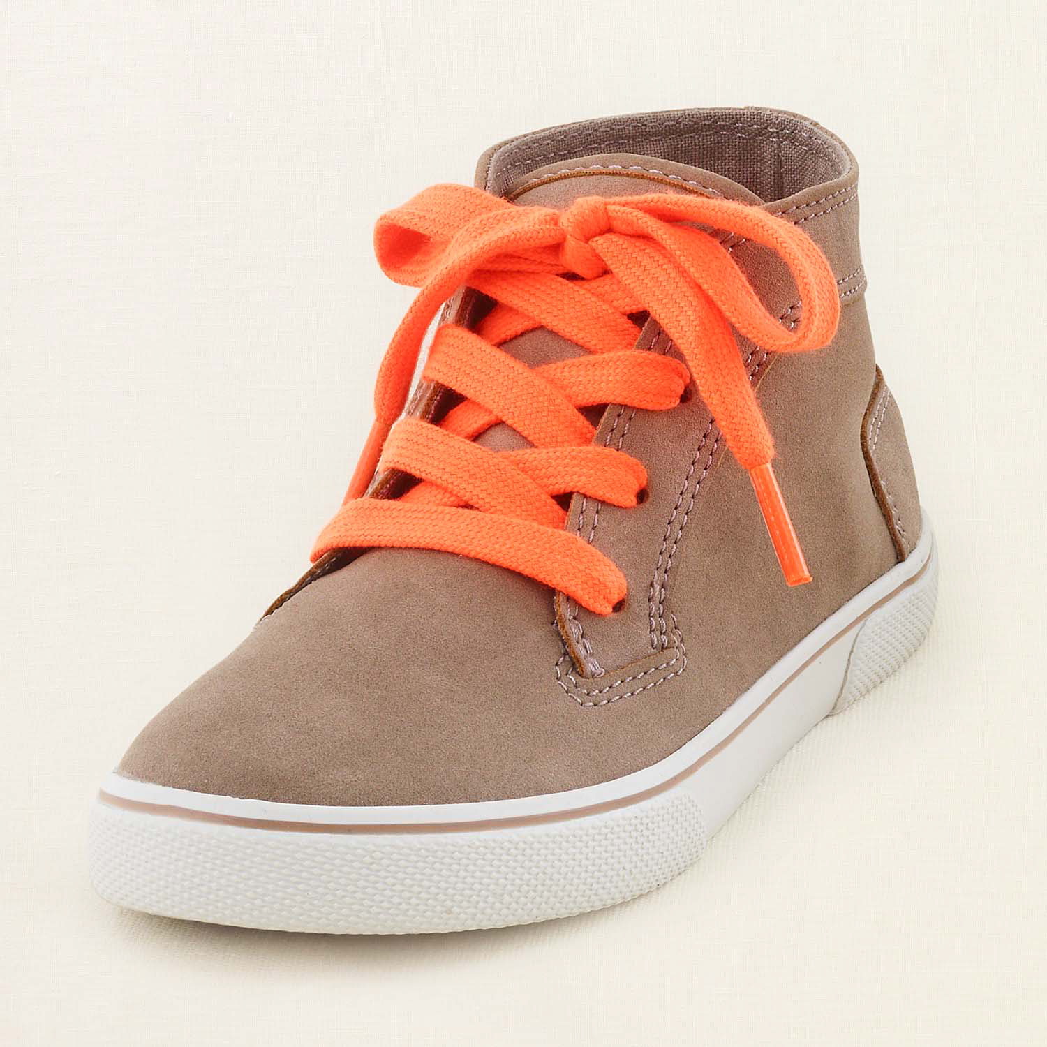 This product image released by The Children's Place shows a camel sneaker with orange neon laces. Unlike so many looks that trickled down from the designer runways into mass retailers and into teenagers' closets, the almost electrifying shades of pink, green, yellow and orange have been hanging out in high school hallways for a while. And they're back again for the new school year.