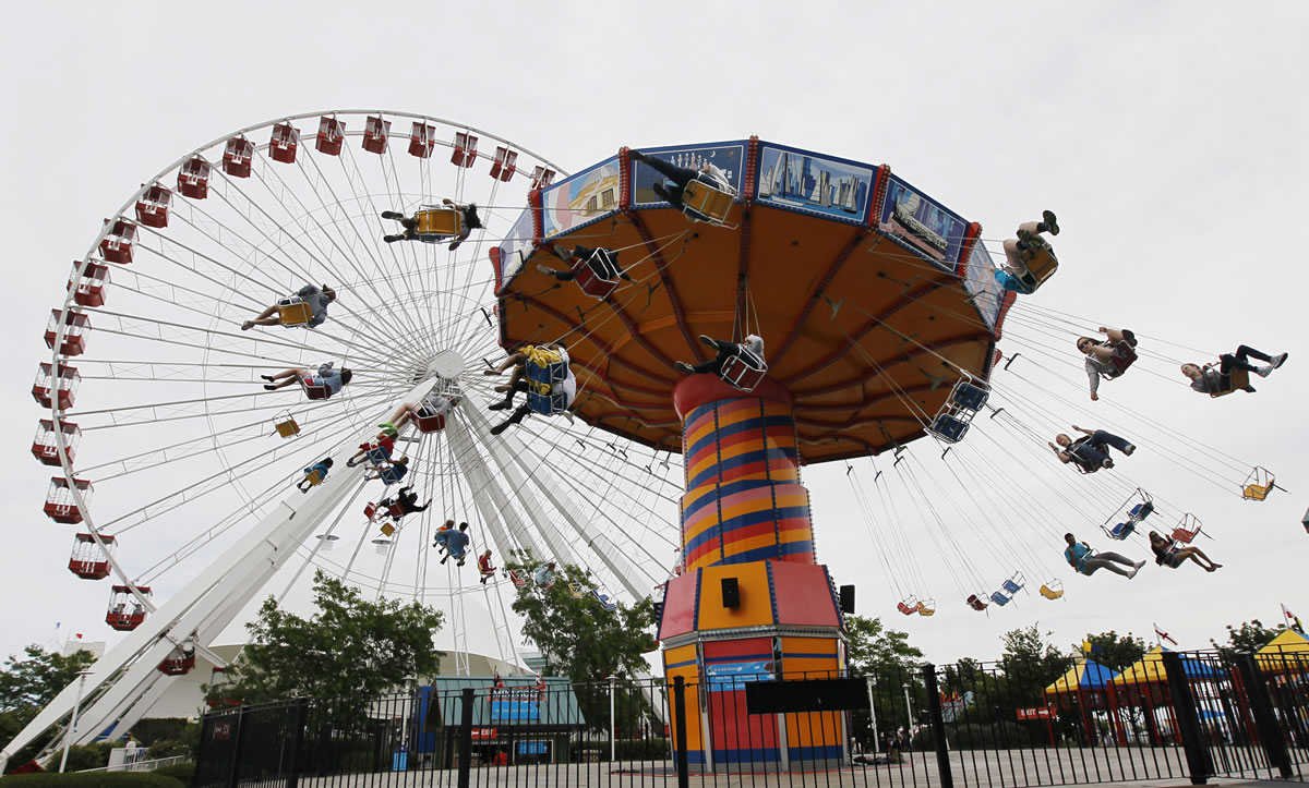 Visitors ride on the Ferris Wheel and Wave Swinger at Chicago's nearly century-old Navy Pier.