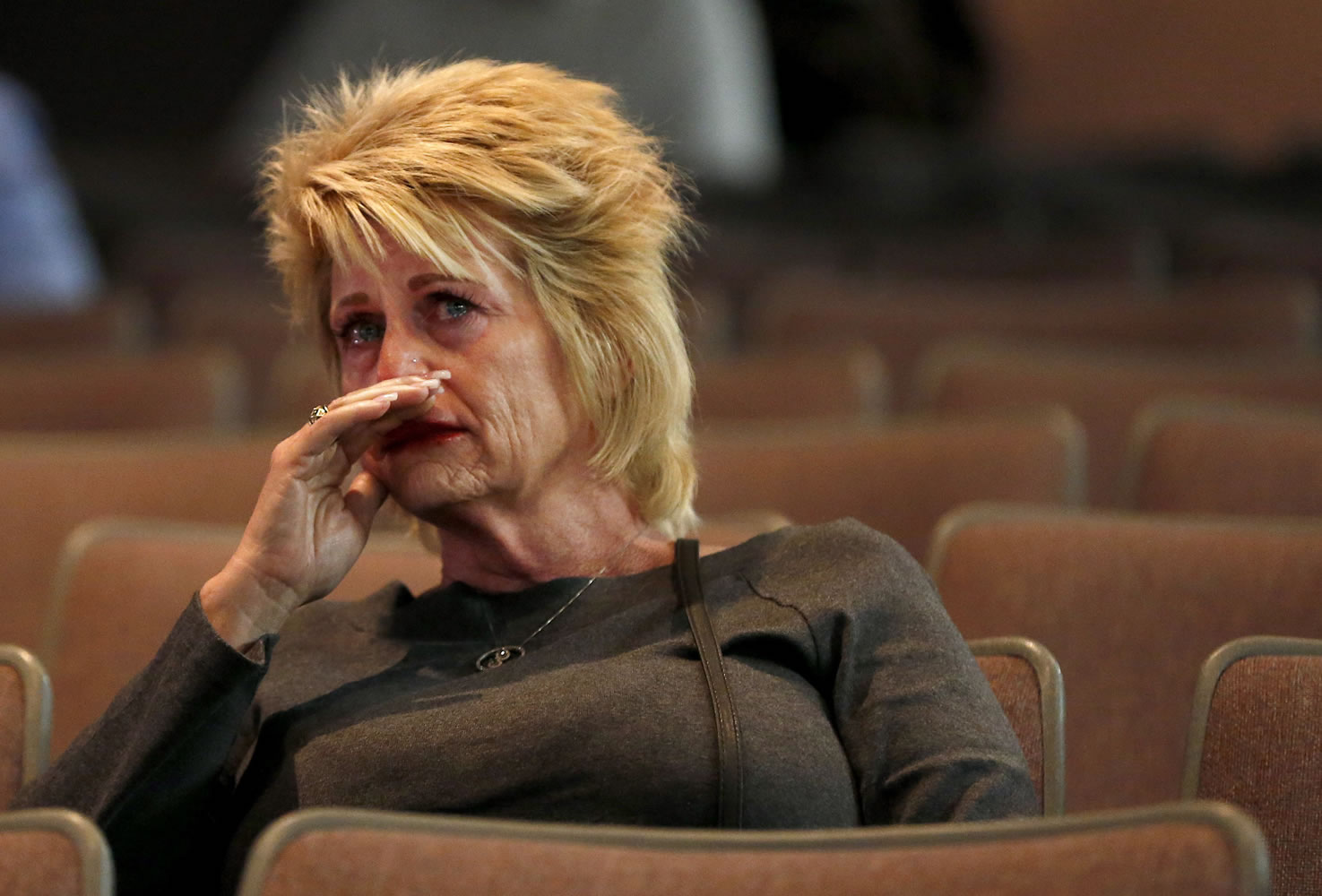 A tearful Shari Turbyfill listens to a panel announce its findings as the official report on the Arizona firefighter deaths is released Saturday in Prescott, Ariz.