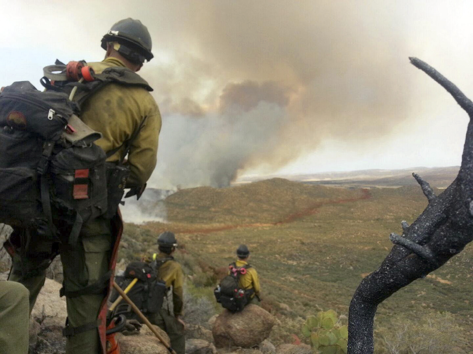 Courtesy of Juliann Ashcraft
In this photo shot by firefighter Andrew Ashcraft, members of the Granite Mountain Hotshots watch a growing wildfire during their lunch break June 30 near Yarnell, Ariz. Ashcraft texted the photo to his wife, Juliann, but died later that day battling the out-of-control blaze.
