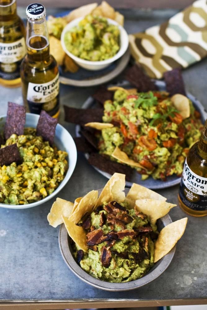 In this image taken on January 7, 2013, sweet heat bacon guacamole, front, chipotle corn guacamole, middle left, shrimp and mango guacamole, top, and roasted fresh salsa guacamole, middle right, are shown served in bowls in Concord, N.H.