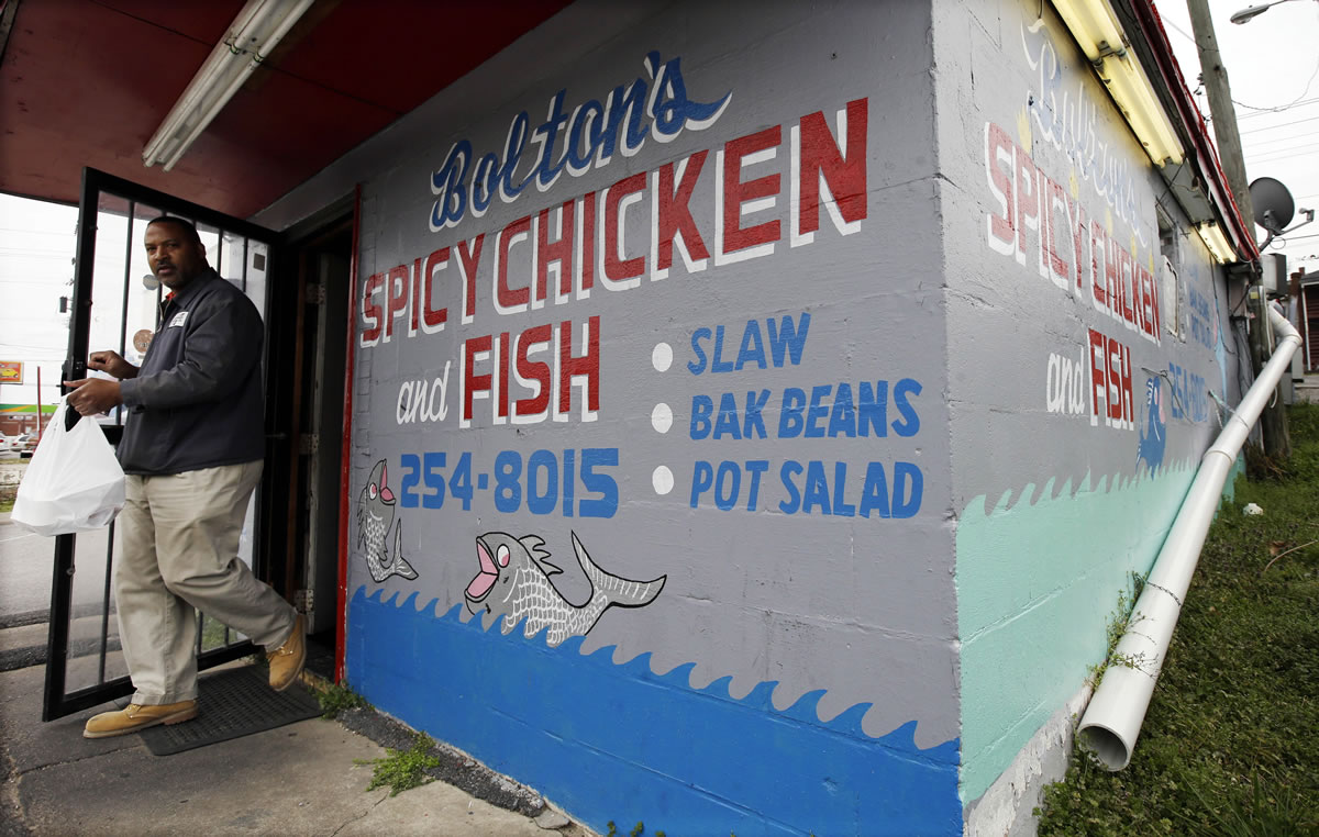 A customer carries out an order from Bolton's Spicy Chicken and Fish restaurant in Nashville, Tenn.