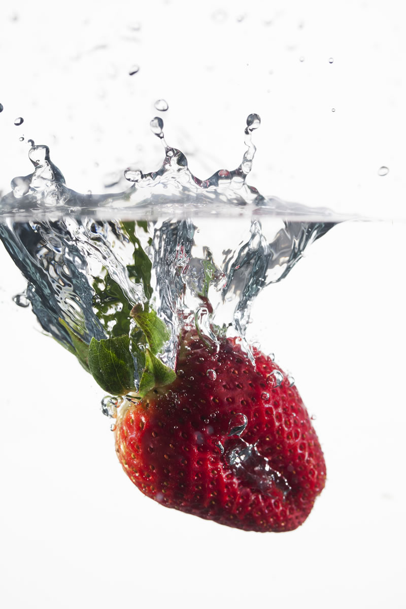 A strawberry is dropped into warm water as it is heat-shocked.