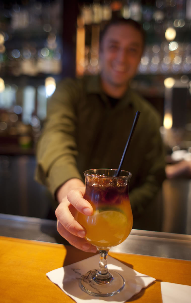 Bartender James Smith delivers a $5 Mai Tai during happy hour at Roy's restaurant in San Francisco.