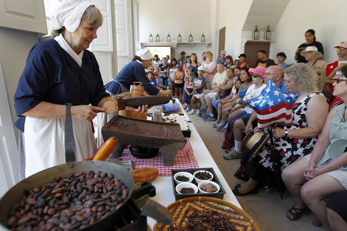 Gail Cassidy, left, a manager of interpretation, and Anette Ahrens, a historical interpreter, demonstrate how to make chocolate ice cream Wednesday at George Washington's Mount Vernon estate in Alexandria, Va.