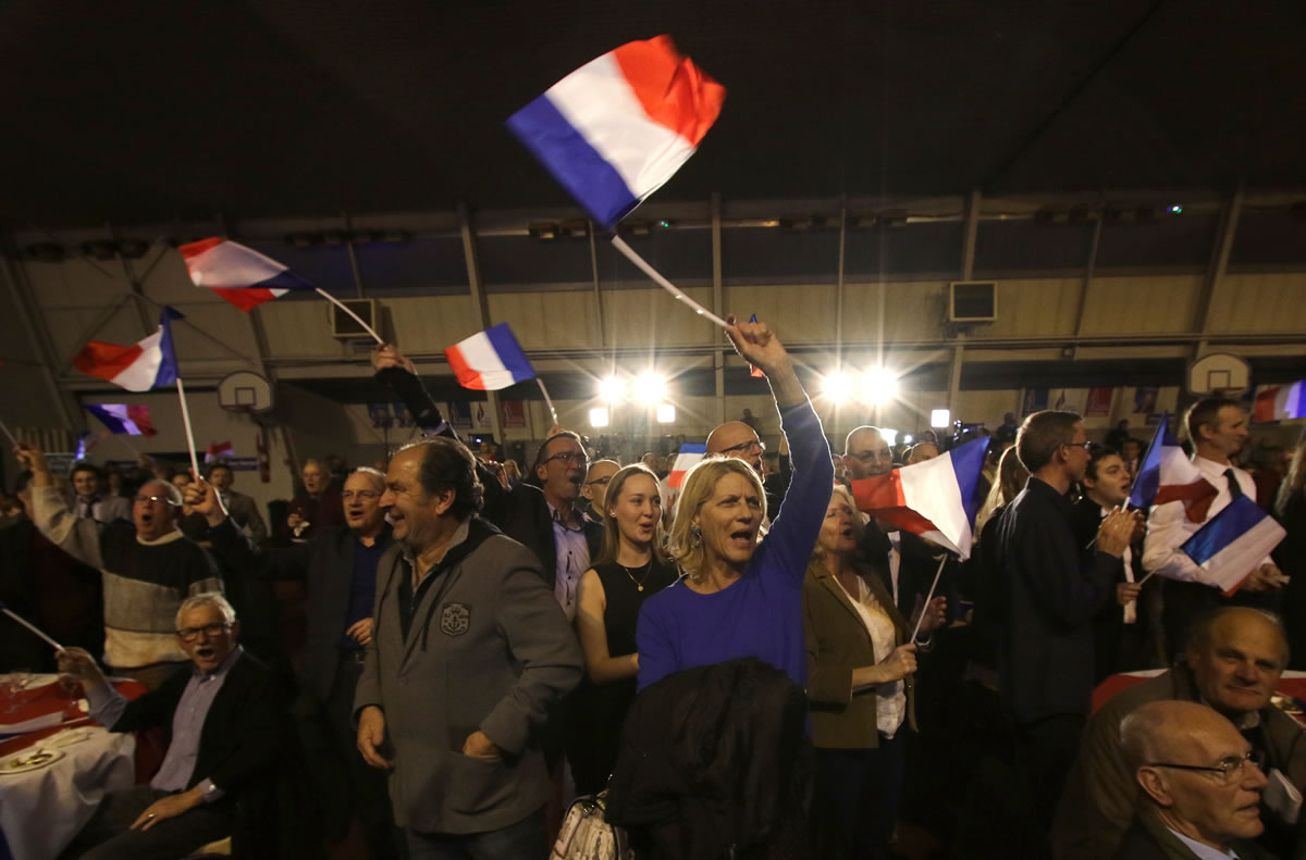 Supporters of Marion Marechal-Le Pen, far right National Front party regional leader for southeastern France, wave flags Sunday at a meeting after the results of the first round of the regional elections, in Carpentras, southern France.