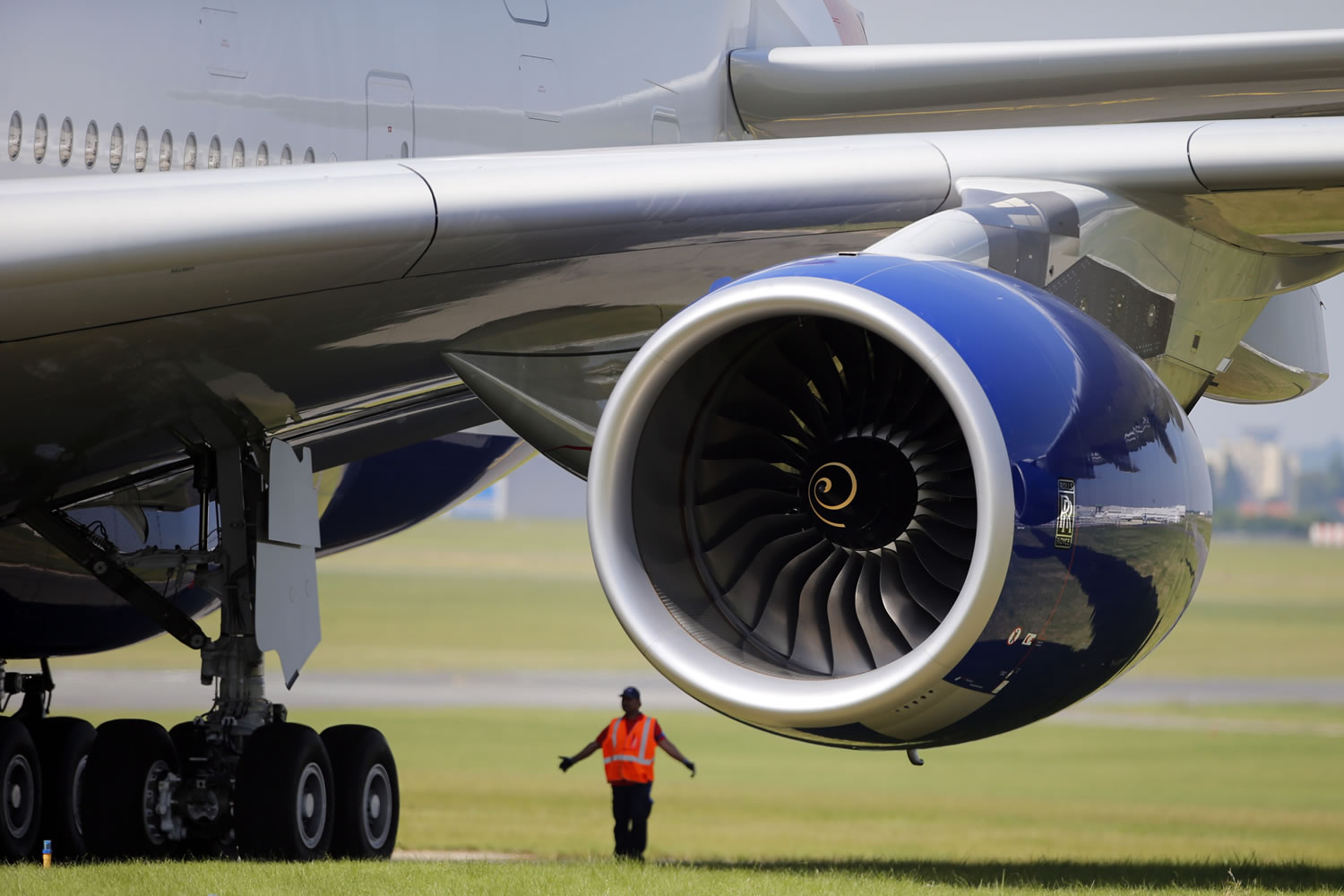 A ground controller stands next to the Rolls Royce engine of a British Airways Airbus A380 during the first day of the 50th Paris Air Show at Le Bourget airport in June.