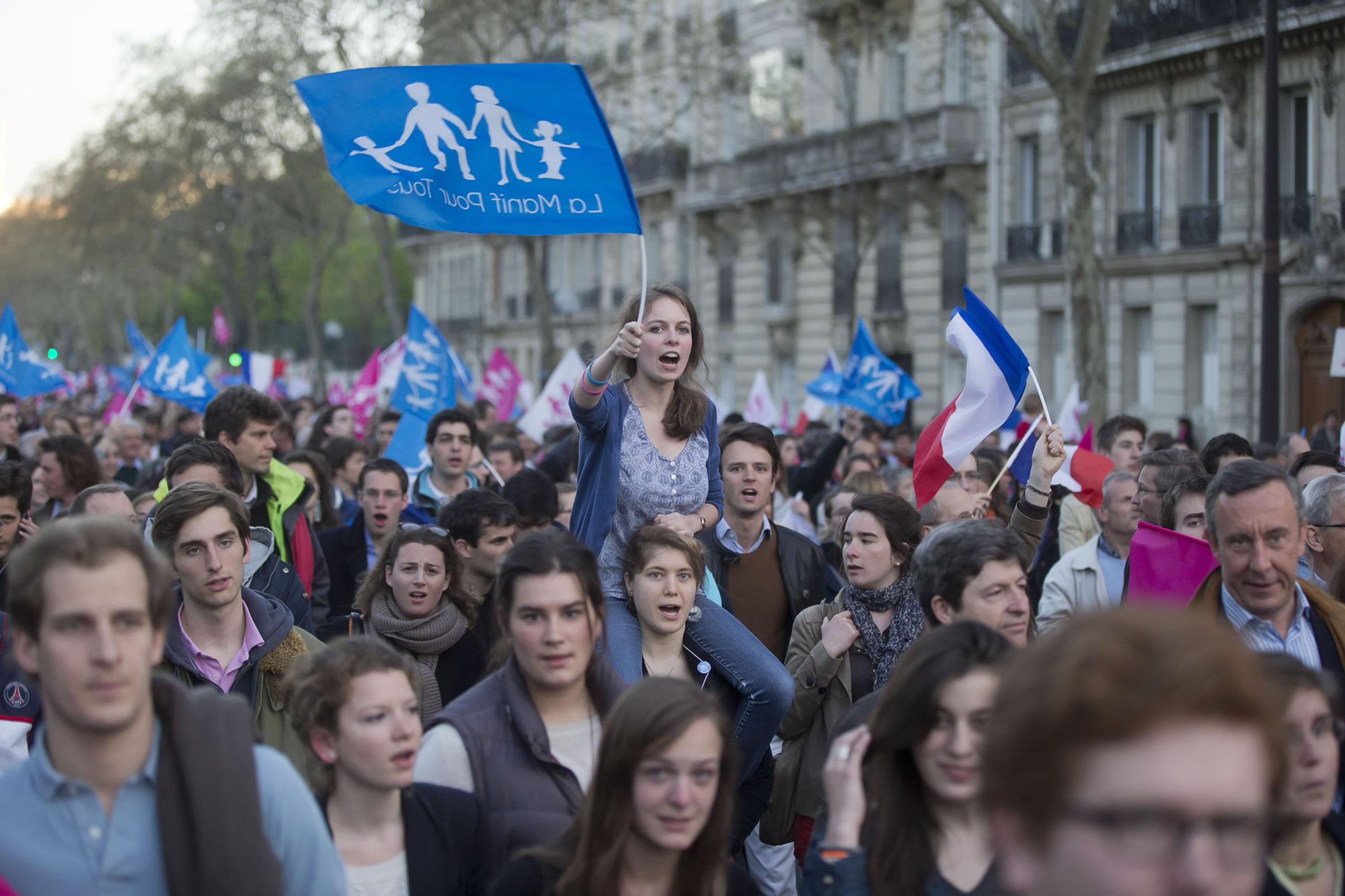 An anti-gay marriage activist waves a flag with the logo of the movement on it during a rally to protest against the new law after French lawmakers legalized same-sex marriage on Tuesday in Paris.