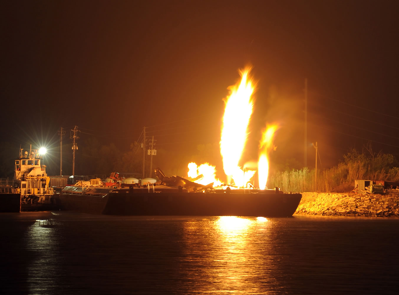 Fire burns aboard two fuel barges along the Mobile River after explosions sent three workers to the hospital Wednesday.