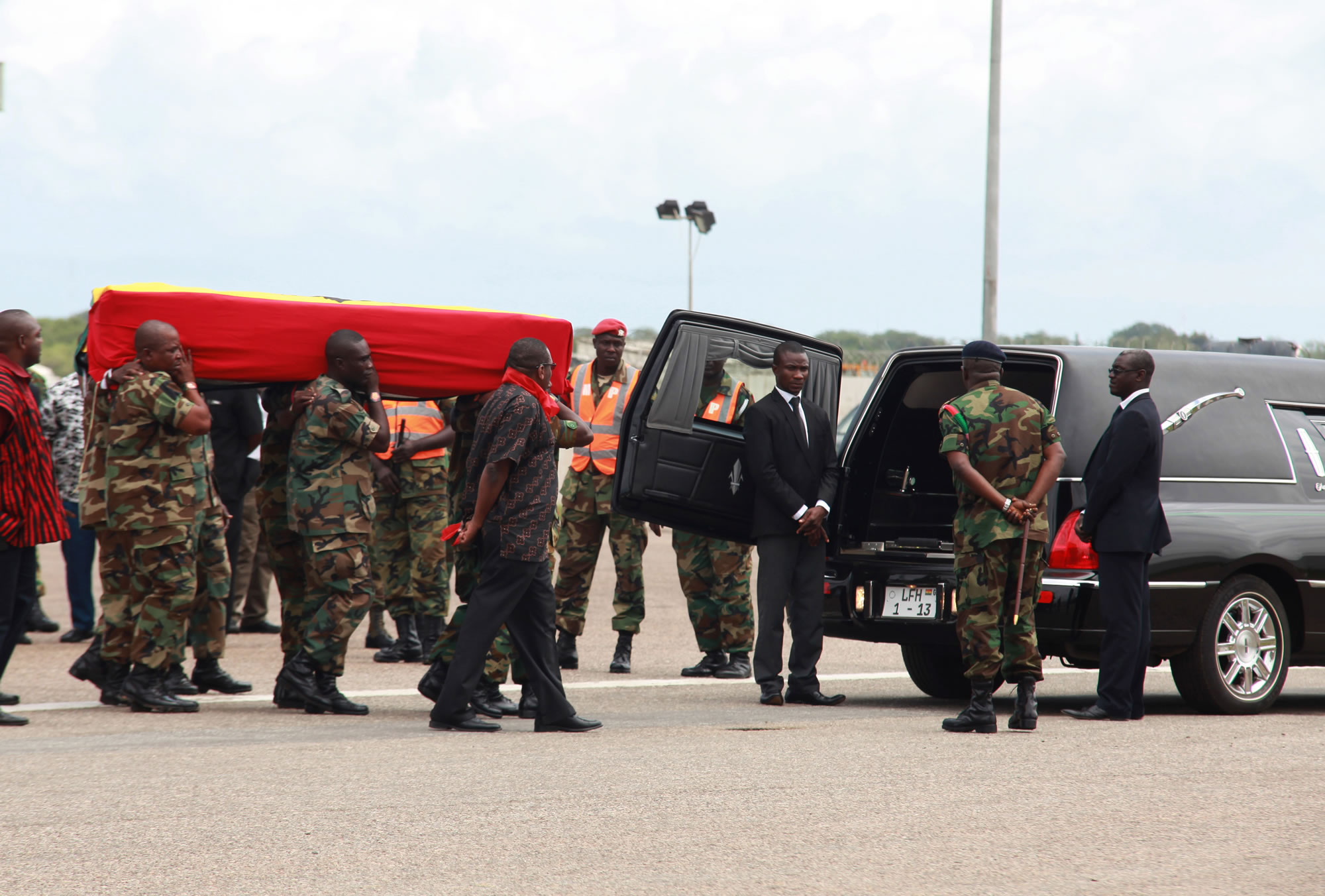 Ghanaian soldiers carry the flag draped coffin of celebrated poet, professor and ambassador Kofi Awoonor after his body was flown back from Kenya, at the airport in Accra, Ghana, on Wednesday. Mourners sang funeral dirges and traditional leaders poured libations Wednesday for the beloved literary icon, as hundreds gathered at the airport where his body was brought home days after he was slain in the Kenya mall terror attack.