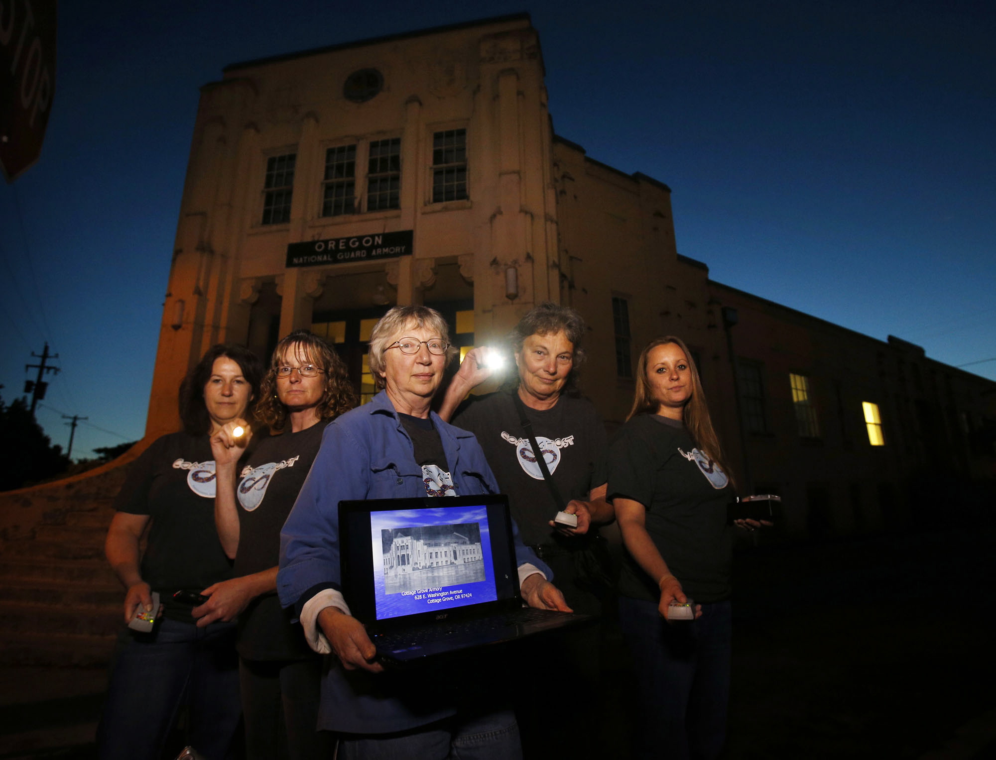 Members of the Coast Ghost Paranormal Research Society including Lisa Hutchinson (left), Christie Best, Denise Cacace, Ann Fillmore and Tiffany Cloud gather at the National Guard Armory in Cottage Grove on June 13 to search for spirits, mostly with military ties, that they claim occupy the 82-year-old building.