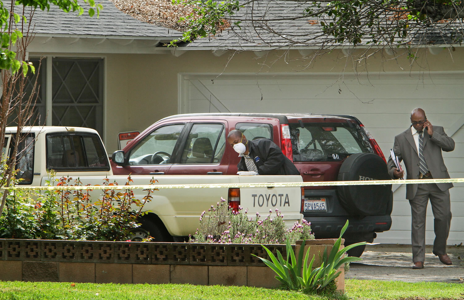 A vehicle is dusted for prints Wednesday in the driveway of a home in Northridge, Calif., where 10-year-old girl disappeared during the night.