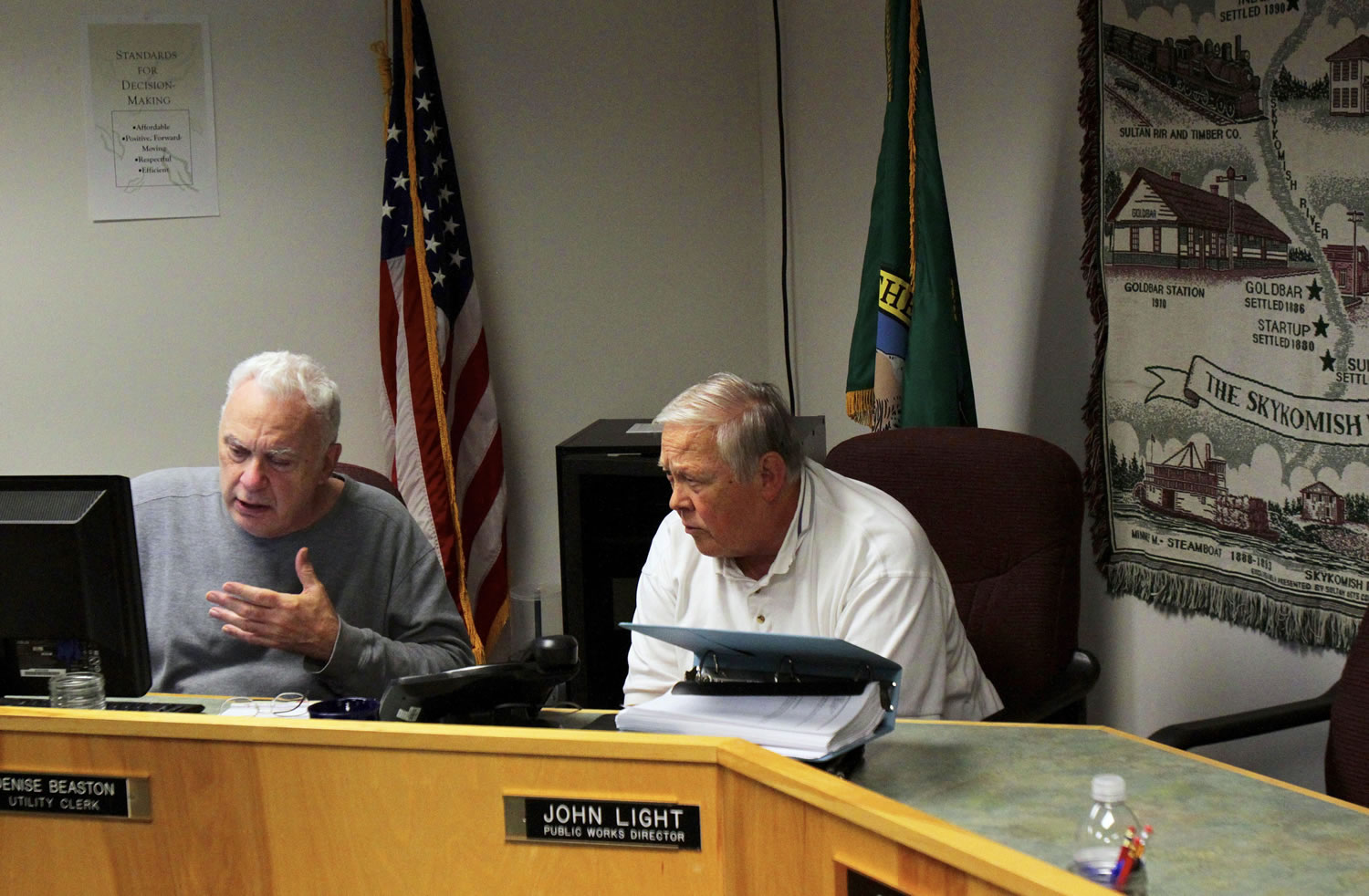 Gold Bar Mayor Joe Beavers, left, and retired resident and volunteer Harry Oestreich take a conference call with banking experts Monday as they try to figure out the next step for the town, which has major financial problems.