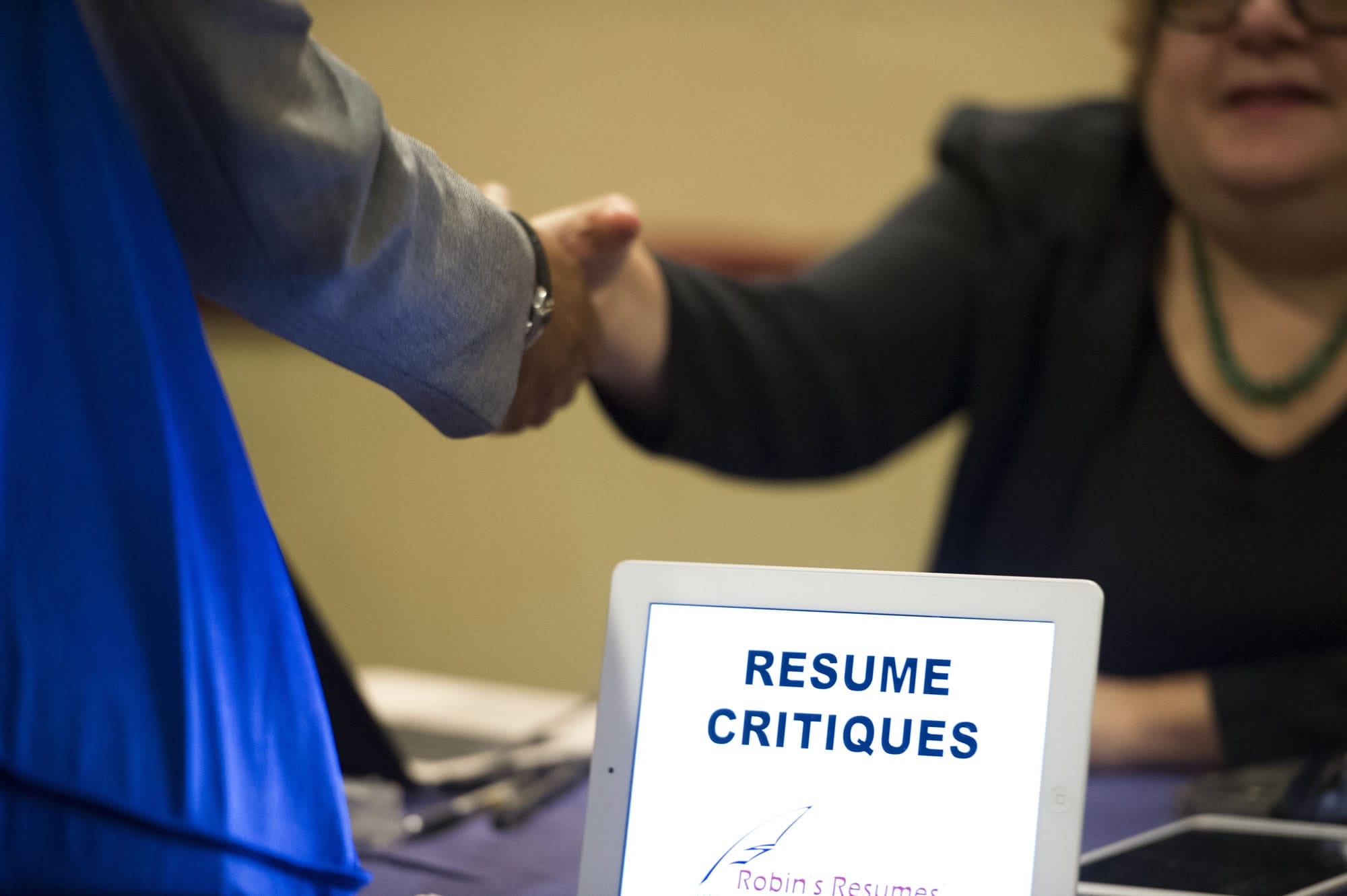 A job seeker stops at a table offering resume critiques during a job fair in Atlanta.