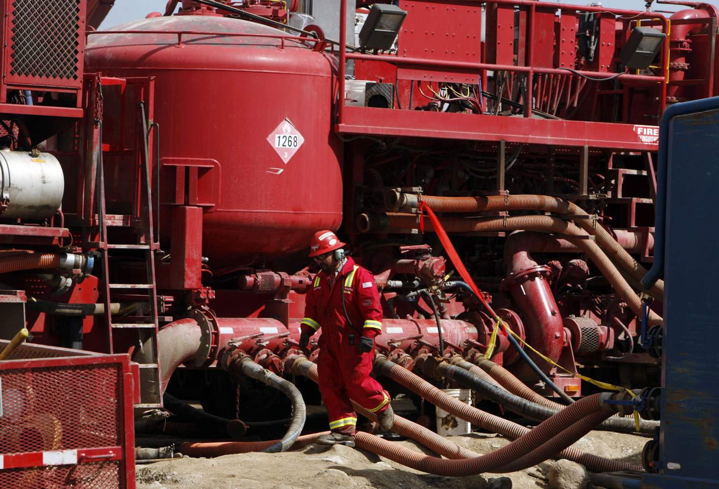 In 2009, an unidentified worker steps through a maze of hoses being used at a remote fracking site being run by Halliburton for natural gas producer Williams in Rulison, Colo.